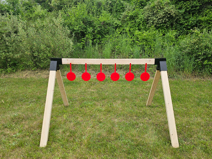 shooting stand at outdoor shooting range with red gun targets mounted to wood