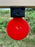 red self healing target mounted upside down used as a swinging target at outdoor gun range 