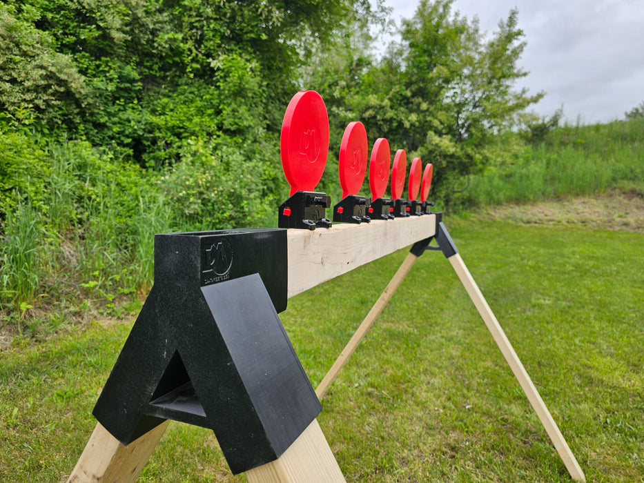 row of red self healing targets mounted to shooting stand at gun shooting range