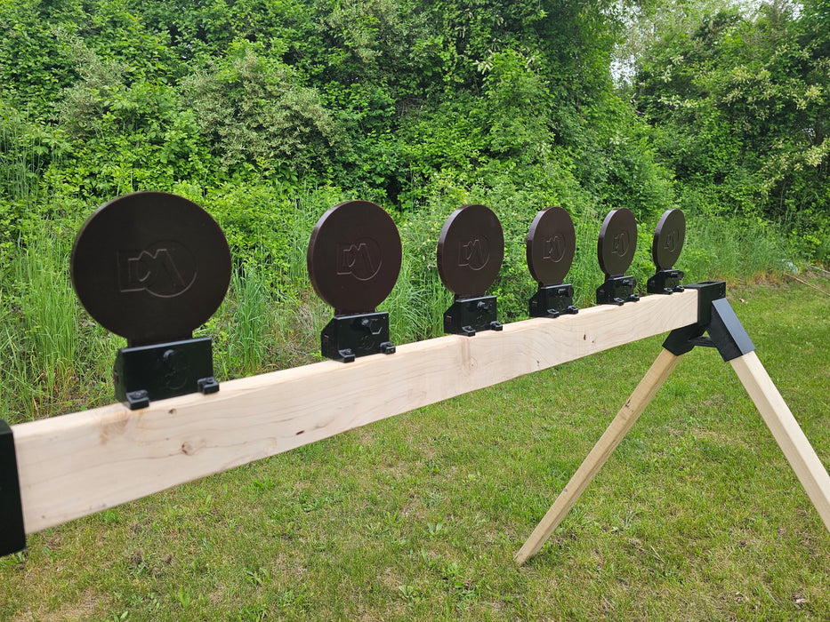 row of knockdown targets mounted to shooting stand at outdoor shooting range