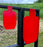 half size and full size silhouette shooting targets red in color mounted to shooting stand at outdoor gun range