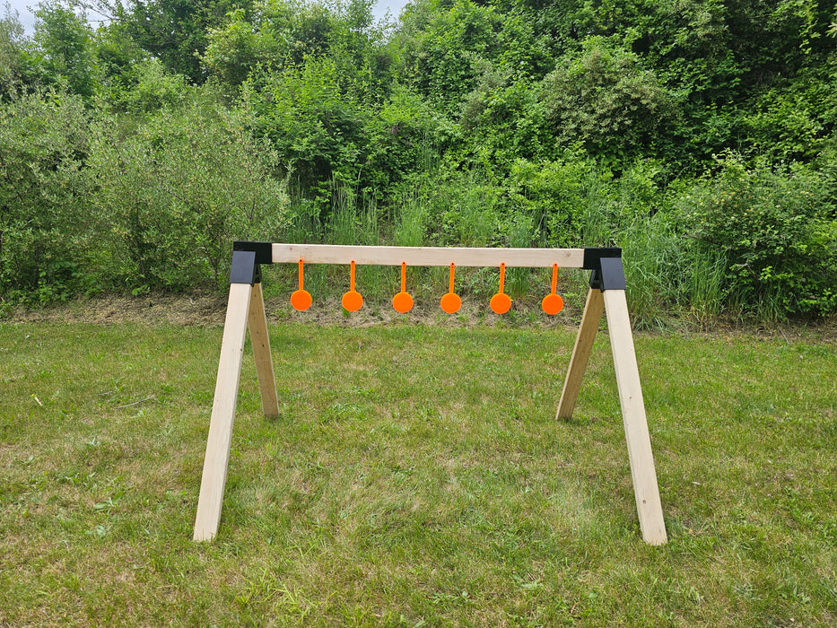 a row of orange self healing gong targets hanging from a wooden rack