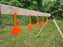 a row of orange self healing gong targets hanging from a wooden rack