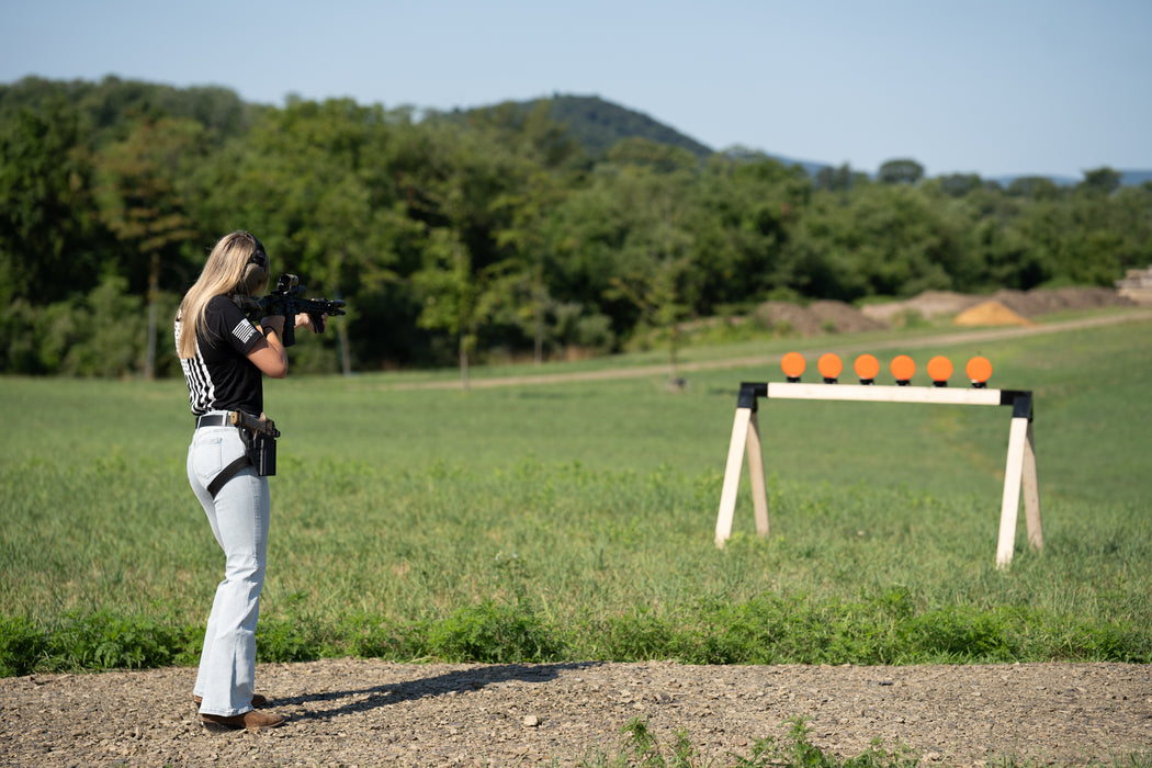 girl shooting self healing targets at target stand with knockdown target mounted to the stand